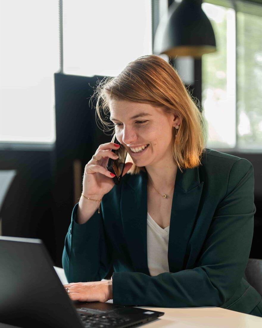Perrine au téléphone avec un client, devant son ordinateur